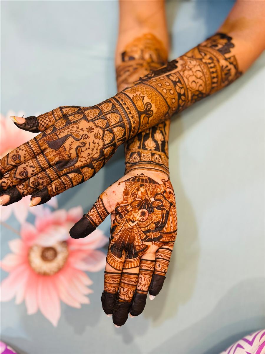 Crossed bridal arms with peacock and Saraswati motifs